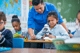 Teacher helping a student look through a microscope at her desk